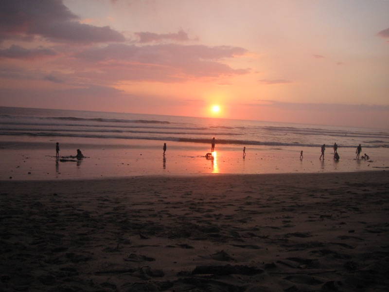 People walking on Playa Santa Teresa at sunset