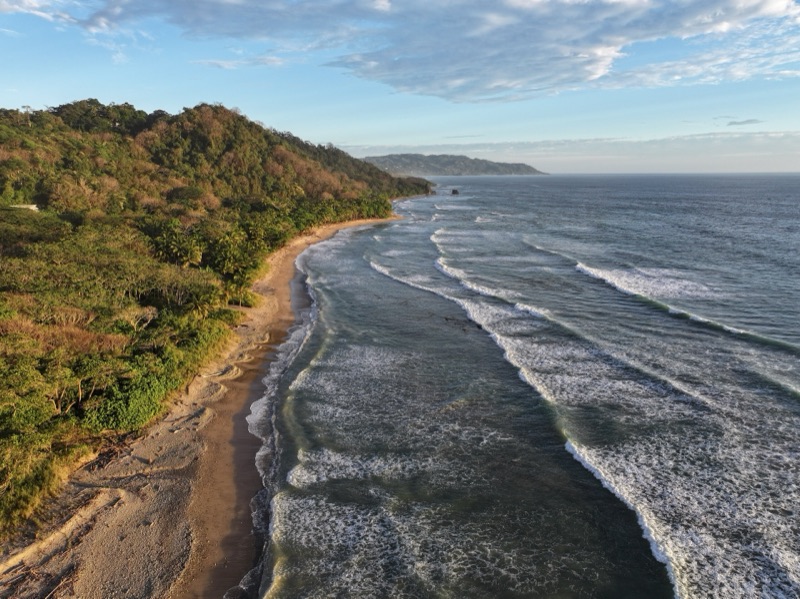 Aerial view of forested hills meeting the Pacific near Cabo Blanco reserve